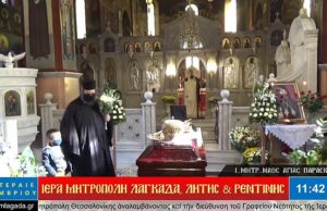 Priest lifts a child up to kiss coffin of a bishop who died of Covid-19